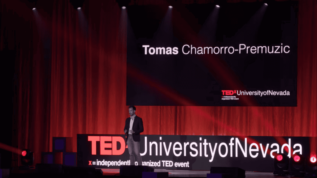 Tomas Chamorro-Premuzic speaking on stage at a TEDx University of Nevada event, discussing leadership selection and competence.
