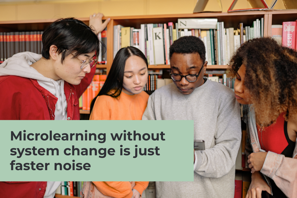 A diverse group of young professionals huddled together looking at a smartphone screen in a library or office, with a green overlay titled "Microlearning without system change is just faster noise."