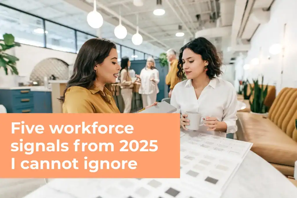 Two women sitting at a cafe table reviewing a document over coffee, with an orange overlay titled "Five workforce signals from 2025 I cannot ignore."