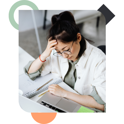 A professional woman looking pensive and hesitant at her laptop, illustrating the internal "small decisions" and perceived risks that lead to a Culture of Flinching in the workplace.