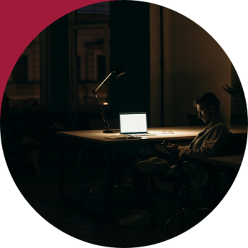 A professional working late in a dark office, representing the burnout and effort behind common team performance patterns like the Alignment Gap and Capacity Crisis.