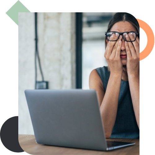 A businesswoman rubbing her eyes in front of a laptop, illustrating the fatigue and frustration caused by an Impact Block and a lack of visible progress despite high effort.