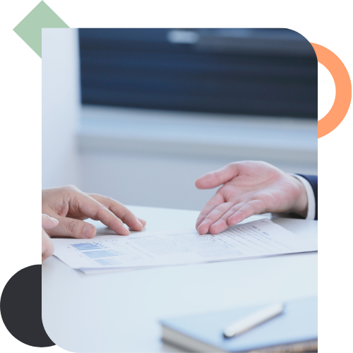 Hands gesturing over a data report in a meeting, representing the tension and difficulty in decision-making when a team is suffering from a capacity crisis.