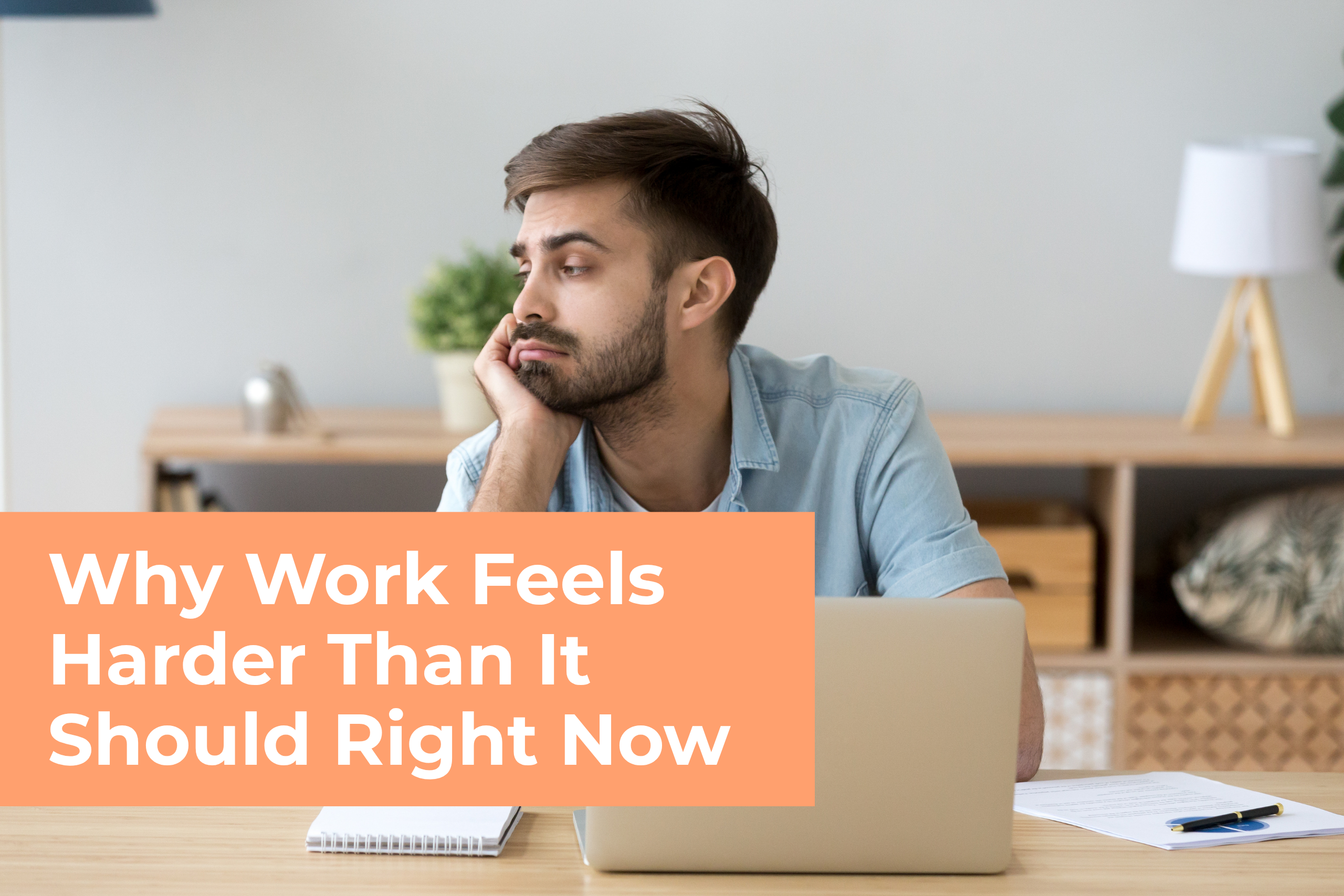 An unmotivated, tired-looking man resting his chin on his hand at a desk, staring blankly past his laptop. A prominent orange box contains the text, "Why Work Feels Harder Than It Should Right Now."